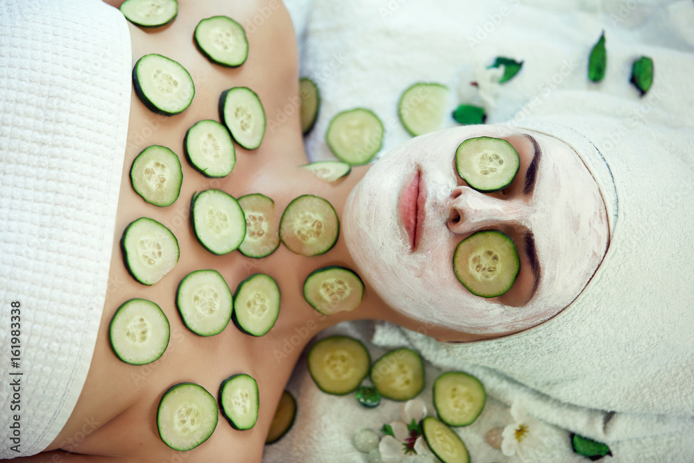 A face mask being applied to a beautiful young woman at a beauty spa A face mask being applied to a beautiful young woman at a beauty spa