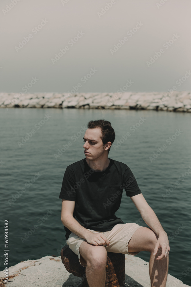 Handsome man sitting posing in the sea