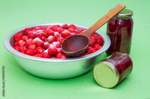 Strawberries in a manufacturer with sugar and jars for making jam. photo