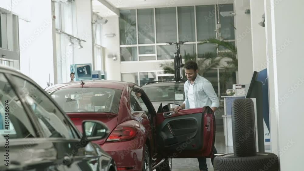Pretty girl asks the boyfriend to buy her a car in car showroom