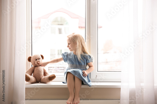 Cute small girl sitting on ...
