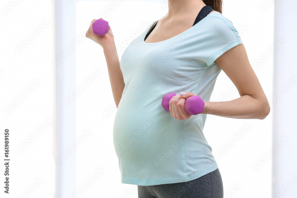 Beautiful pregnant woman doing exercise indoors Beautiful pregnant woman doing exercise indoors