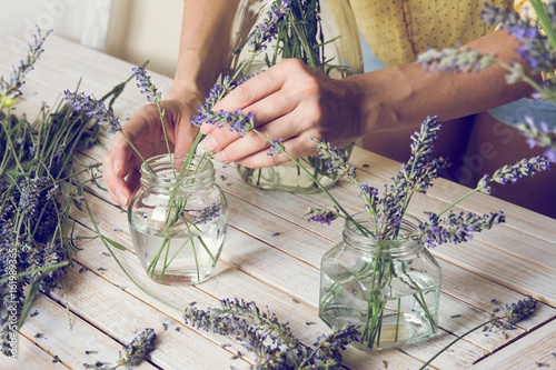 Fototapeta Naklejka Na Ścianę i Meble -  Florist at work: Creating small bouquets of natural lavender flowers