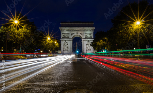 The Arc de Triomphe de l'Etoile (Triumphal Arch of the Star) at Night. It is one of the most famous monuments in Paris, standing at the western end of the Champs-Elyseees. © Anatoly