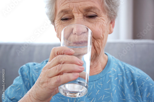 Elderly woman drinking wate...