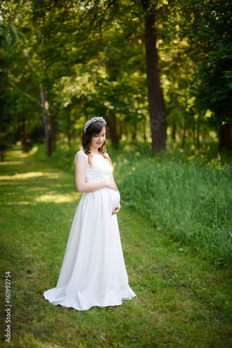 pregnant girl is walking around the city park © Nestyda