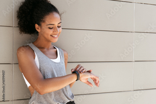 Fitness woman taking a break, checking activity tracker