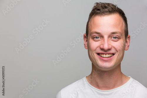 Canvas Print Portrait of a handsome young man, perfectly calm, facing the camera with emotion