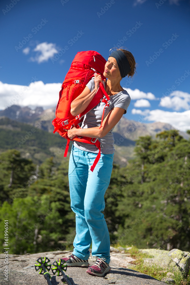 Pretty, female hiker in high mountains with her backpack