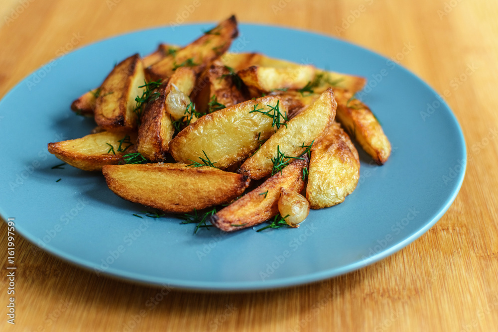Roasted potatoes with salt pepper and cumin on wooden background Roasted potatoes with salt pepper and cumin on wooden background