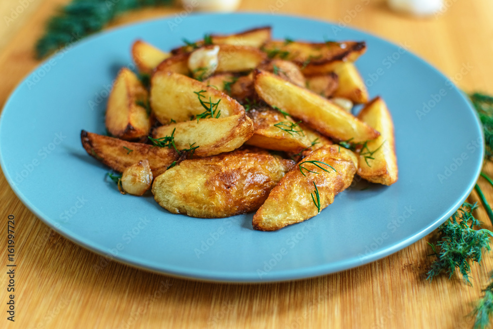 Roasted potatoes with salt pepper and cumin on wooden background
