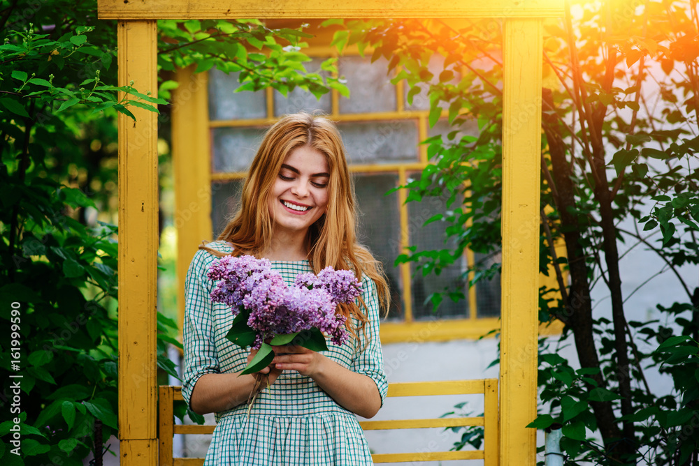 Beautiful young woman with bouquet of lilac in spring garden Beautiful young woman with bouquet of lilac in spring garden