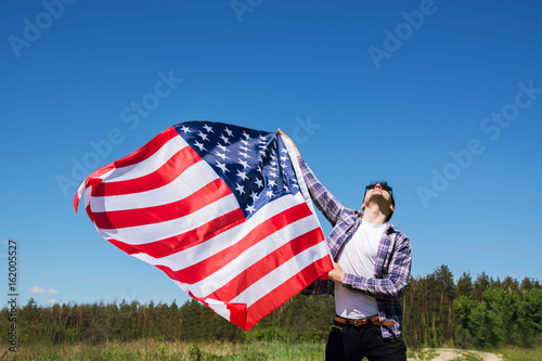 man is holding waving american USA flag. 