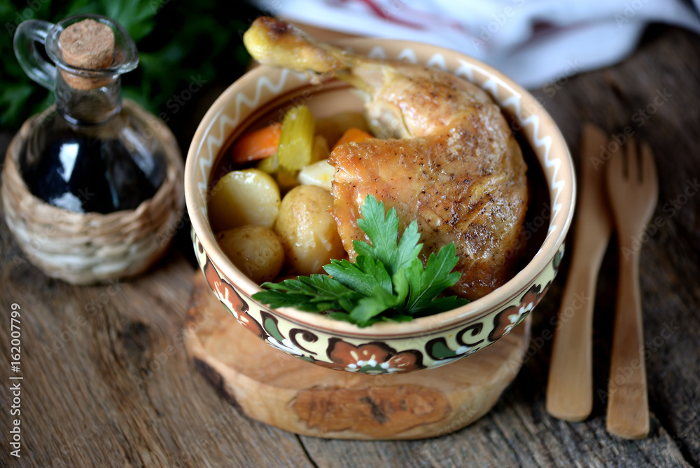 Chicken leg baked with potatoes, carrots, celery and onions.
