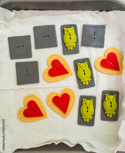 arts and craft polymer clay owl buttons and hearts ready for baking. Hobby, handicraft background. Working process. Trend jewelry.