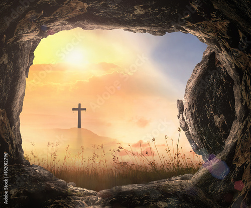 Resurrection of Jesus Christ concept: Tomb empty with cross at autumn sunrise background