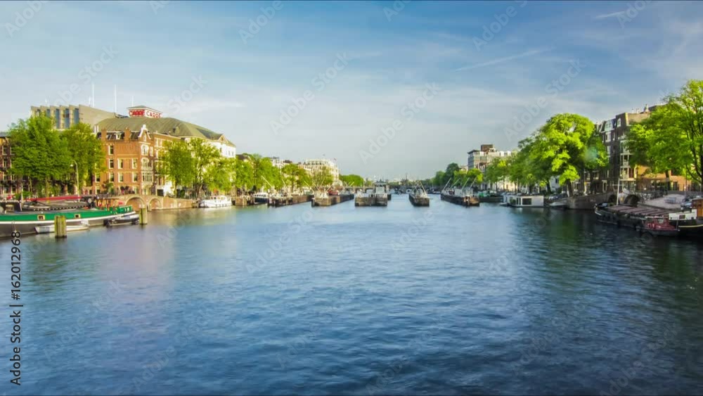 Time lapse of water transport on city river channel. Timelapse of river traffic on river town. Ship sailing on water channel. Ship river traffic. Water city. Water transport traffic on waterway Time lapse of water transport on city river channel. Timelapse of river traffic on river town. Ship sailing on water channel. Ship river traffic. Water city. Water transport traffic on waterway