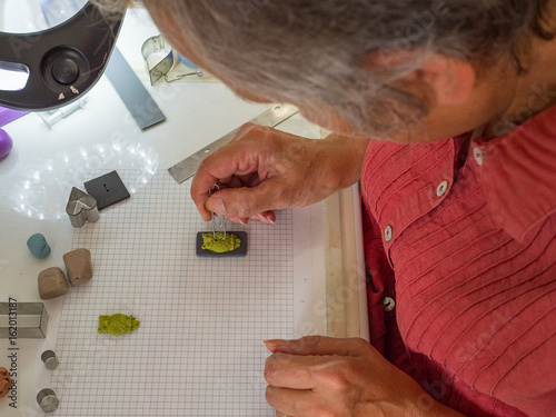 Woman hand making owl button from polymer clay. Hobby, handicraft background. Working process. Trend jewelry. photo