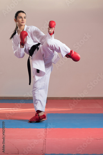 Woman In White Kimono And Black Belt Training Karate