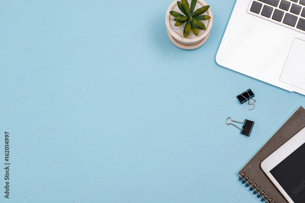 Fotografie Top view workspace mockup on blue desk with notebook.