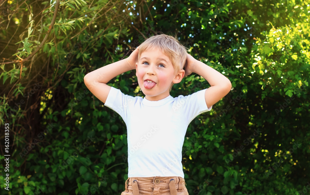 Baby boy playing in park with happy smiling face and blond hair showing tongue and making face, Baby boy playing in park with happy smiling face and blond hair showing tongue and making face,