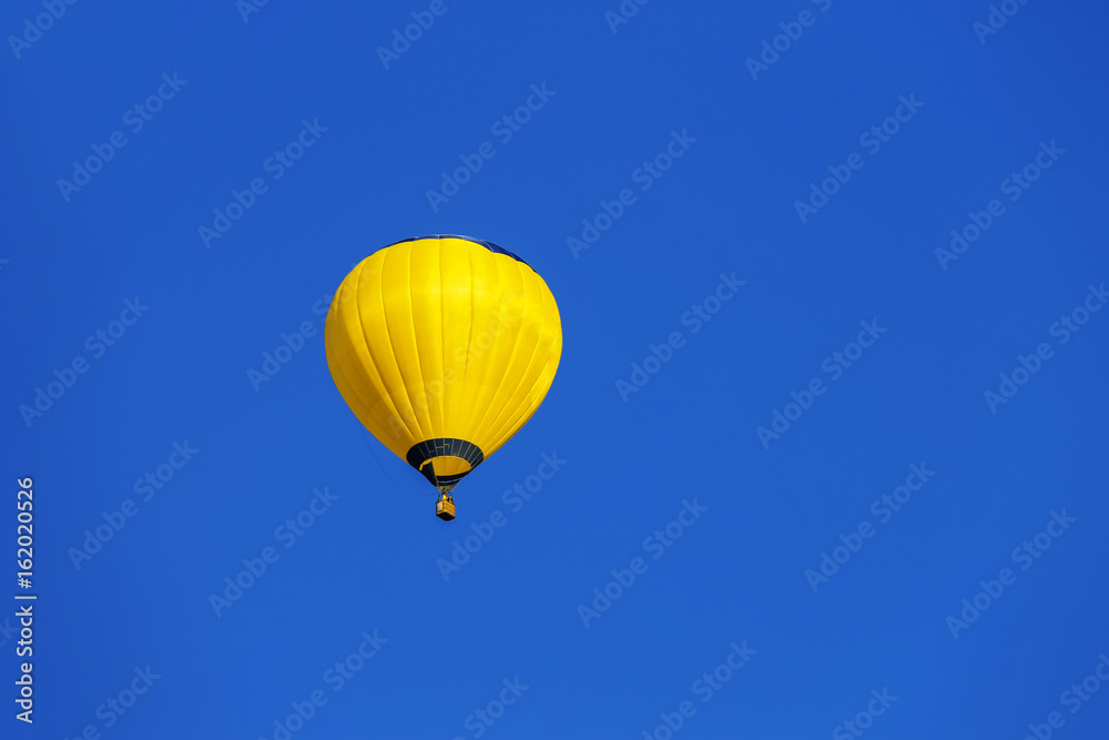Naklejka premium Yellow balloon in blue sky