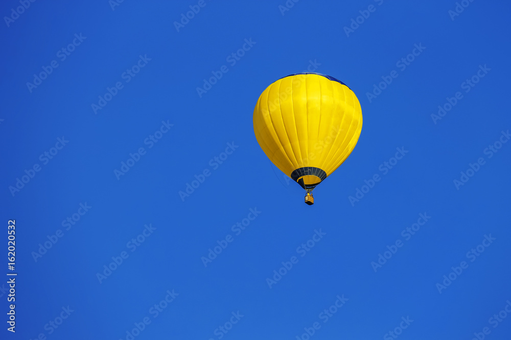 Yellow balloon in blue sky