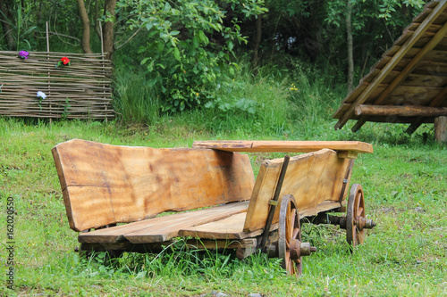 Decorative wooden cart on green grass in Carpatian park