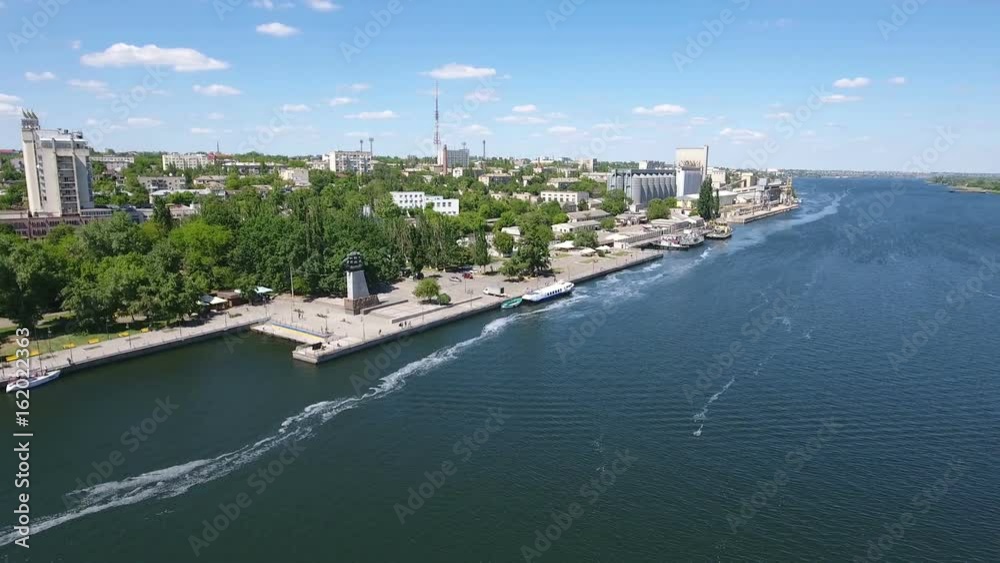 Marvelous aerial shot of the Dnipro and its picturesque riverbanks in Kherson region in Ukraine in a sunny day in summer. The quay with modern buildings looks fine and gorgeous. Marvelous aerial shot of the Dnipro and its picturesque riverbanks in Kherson region in Ukraine in a sunny day in summer. The quay with modern buildings looks fine and gorgeous.