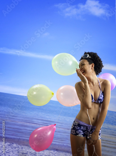 woman having fun with the balloons at the beach