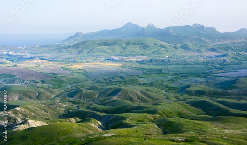 Green hills agaist mountain ridge