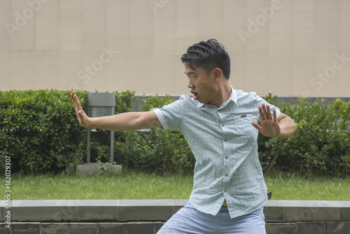 Asian young man display Chinese KongFu. Or young Man In a Fight. Business concept.