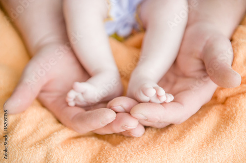 Baby feet cupped into mothers hands © Ermolaev Alexandr