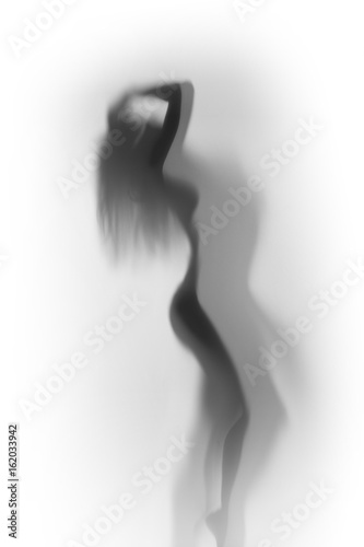 Beautiful and sexy woman body silhouette behind a glass surface
