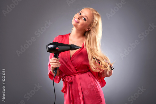 Foto Young woman with hairdryer