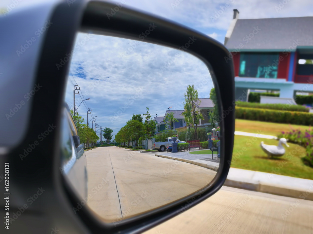 The car mirror looked through the village in Thailand