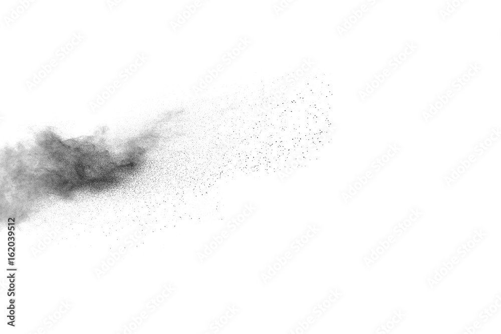 Black powder explosion. Closeup of black dust particles explode isolated on white background.