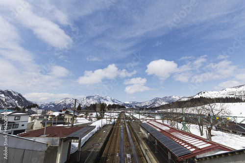 越後中里駅と雪山の風景 © sasasarururu