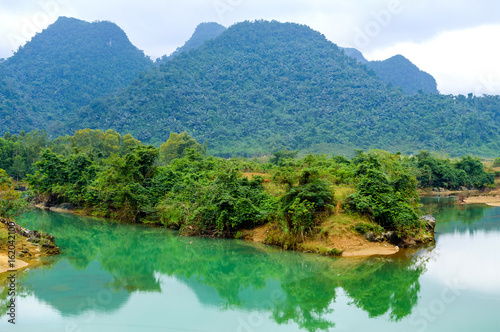 A river with green water and clay banks