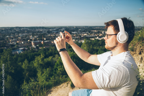 man taking picture on the top of the hill photo