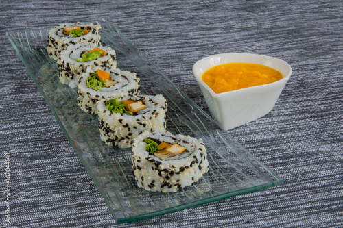 Vegan sushi on glass plate with sauce photo