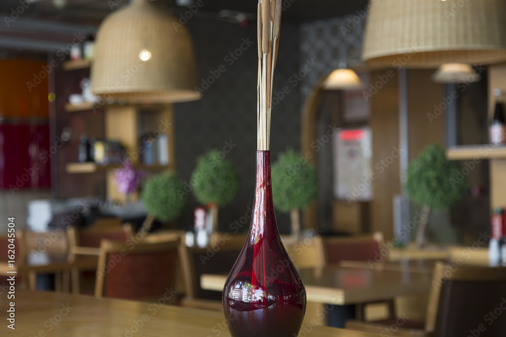red vase with a blurred background on a table in a restaurant 