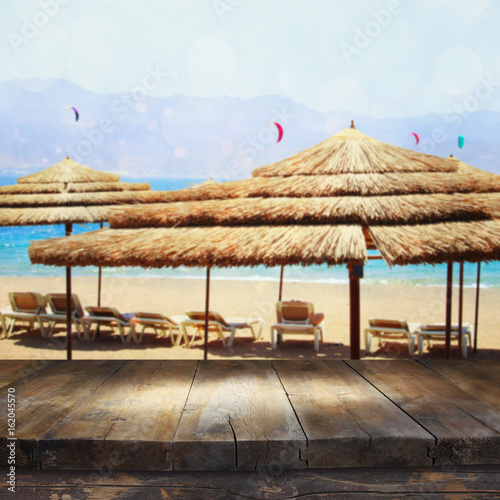 Empty old table in front of tropical sea and beach. Useful for product display montage
