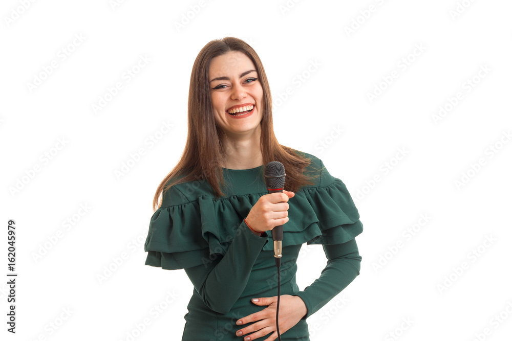 Happy woman laughing with microphone in hands in green dress Happy woman laughing with microphone in hands in green dress