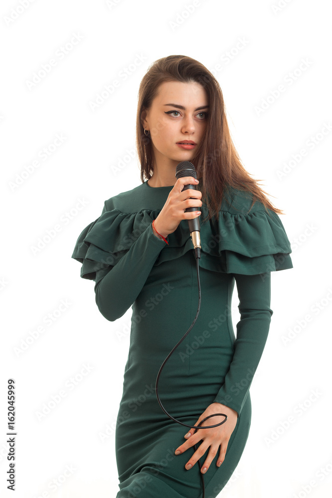 Vertical portrait of beautiful woman in green dress sings a karaoke in microphone Vertical portrait of beautiful woman in green dress sings a karaoke in microphone