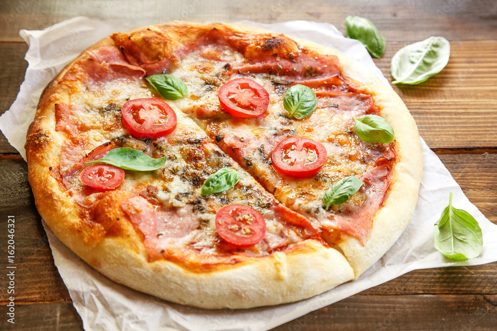 Pizza. Fresh Italian margherita with salami, basil and tomato on a wooden table Pizza. Fresh Italian margherita with salami, basil and tomato on a wooden table