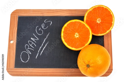 Canvastavla Oranges posées sur une ardoise