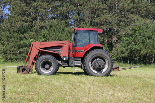 Red Farm Tractor on a green grass pasture