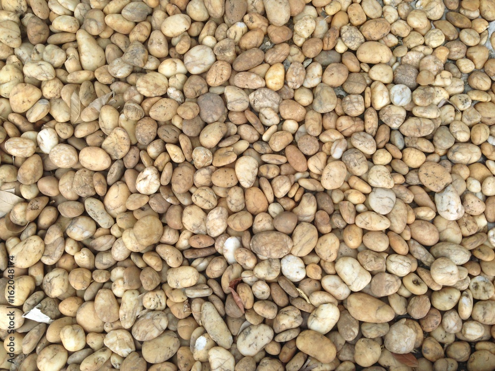 The background consists of several brown and round stones The background consists of several brown and round stones