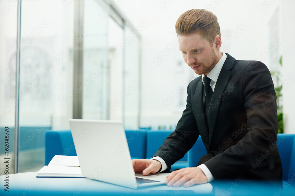 Businessman concentrating on networking at workplace Businessman concentrating on networking at workplace